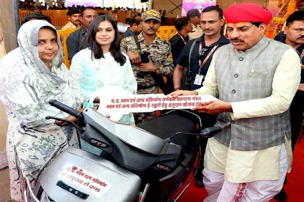 ई-स्कूटर के पास सायरा बी और मुख्यमंत्री; बीच में चाबी का प्रतीक